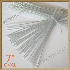 May include: A bundle of 7 inch oval-shaped, silver-colored wire floral stems. The stems are packaged in a clear plastic bag. The text "7" inch oval" is printed in orange on a white background.