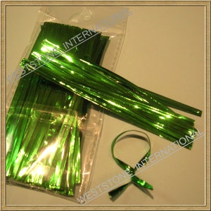 May include: A package of green metallic curling ribbon. The ribbon is in a clear plastic bag and there is a green ribbon tied in a bow on the table.