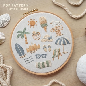 May include: A circular wooden embroidery hoop containing a light beige fabric with various embroidered summer icons including a sun, ice cream, palm tree, coconut, beach sign, hat, surfboard, sandcastle, flip-flops, umbrella, chair, and sunglasses.