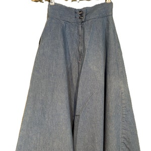 May include: A high-waisted denim skirt with a flared silhouette. The skirt is a light blue color and has a button closure at the front.