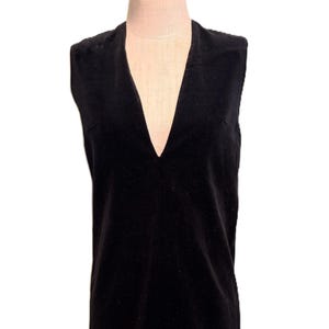 May include: A sleeveless black velvet dress with a deep V-neckline.