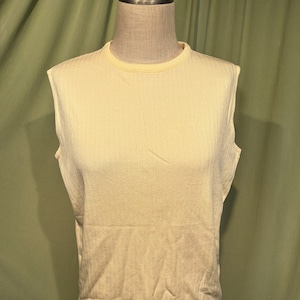 May include: A sleeveless, pale yellow ribbed knit top with a round neckline.