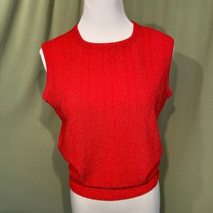 Peut inclure: Un pull rouge sans manches avec une texture côtelée.