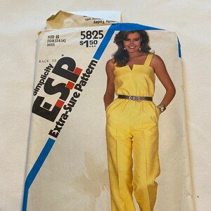 May include: Simplicity pattern number 5825 for a yellow jumpsuit with a V-neck and a belt. The pattern is for sizes 10, 12, and 14.