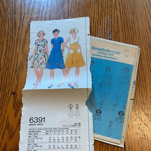 May include: A sewing pattern for a dress with three different views. The pattern is Simplicity 6391 and includes instructions for cutting and sewing. The dress is available in sizes 6-18 and requires 2 1/4 to 3 9/16 yards of fabric.