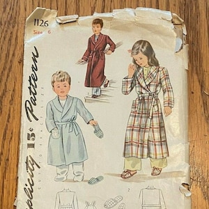 Könnte beinhalten: Vintage Simplicity Schnittmuster 1126, Größe 6, für einen Kinderbademantel. Das Schnittmuster enthält Anleitungen zum Nähen eines Bademantels mit Gürtel und Taschen. Das Schnittmuster ist auf Papier mit hellbraunem Hintergrund gedruckt und zeigt Illustrationen von Kindern, die den Bademantel tragen.