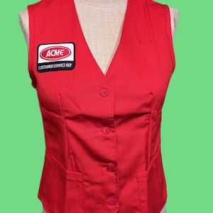 May include: A red vest with a V-neck and three buttons. The vest has two pockets and a patch that reads "ACME CUSTOMER SERVICE REP."