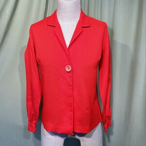 May include: A red long-sleeved button-up shirt with a collar. The shirt has a single button closure and a slightly fitted silhouette.