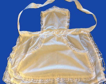 Grembiule da bambina vintage originale in nylon bianco sporco con rifiniture in pizzo e tasca