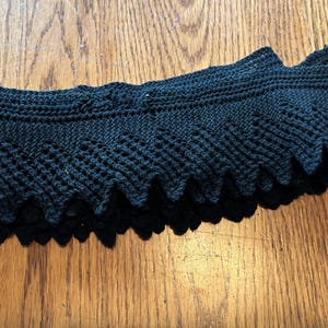 May include: Black crocheted lace trim with a scalloped edge.