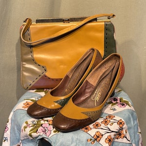 May include: Two brown and gold leather shoes with a geometric pattern and a brown leather purse with gold hardware and a geometric pattern.