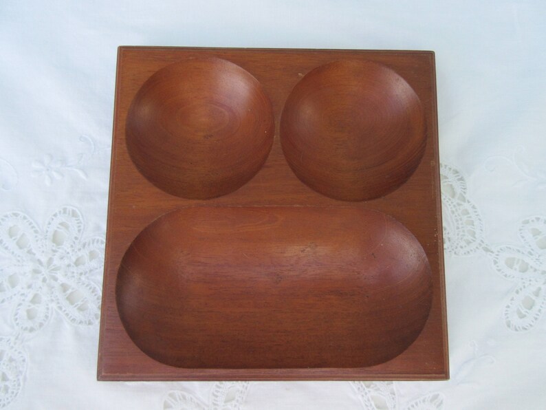May include: A wooden serving tray with three separate compartments. The tray is made of dark brown wood and has a smooth, polished finish.