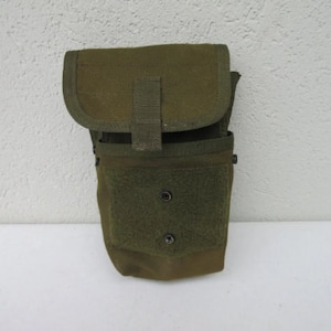 May include: A green canvas utility pouch with a flap closure and a zippered pocket. The pouch has two rows of stitching and a small strap with a buckle.