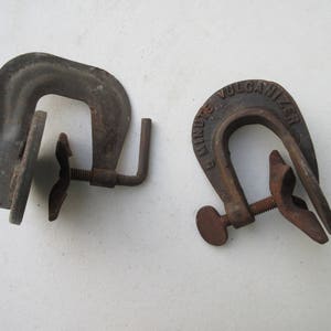 May include: Two vintage metal clamps. One clamp is labeled "5 Minute Vulcanizer".