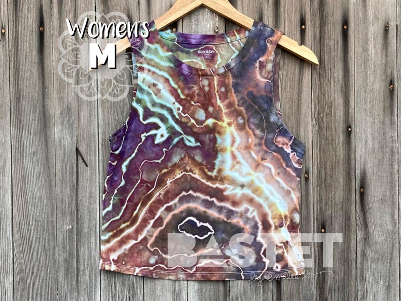 May include: A tie-dye tank top in shades of brown, purple, and blue. The tank top has a relaxed fit and a scoop neck. The tank top is made of a soft, comfortable fabric.