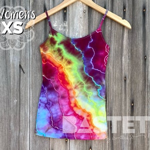Peut inclure: Un débardeur tie-dye avec un motif arc-en-ciel. Le débardeur est sur un cintre et porte une étiquette de taille indiquant "Women's XS".