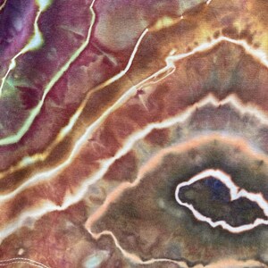 May include: Close-up of a tie-dye fabric with a swirling pattern of brown, orange, and white. The fabric has a soft, textured feel.