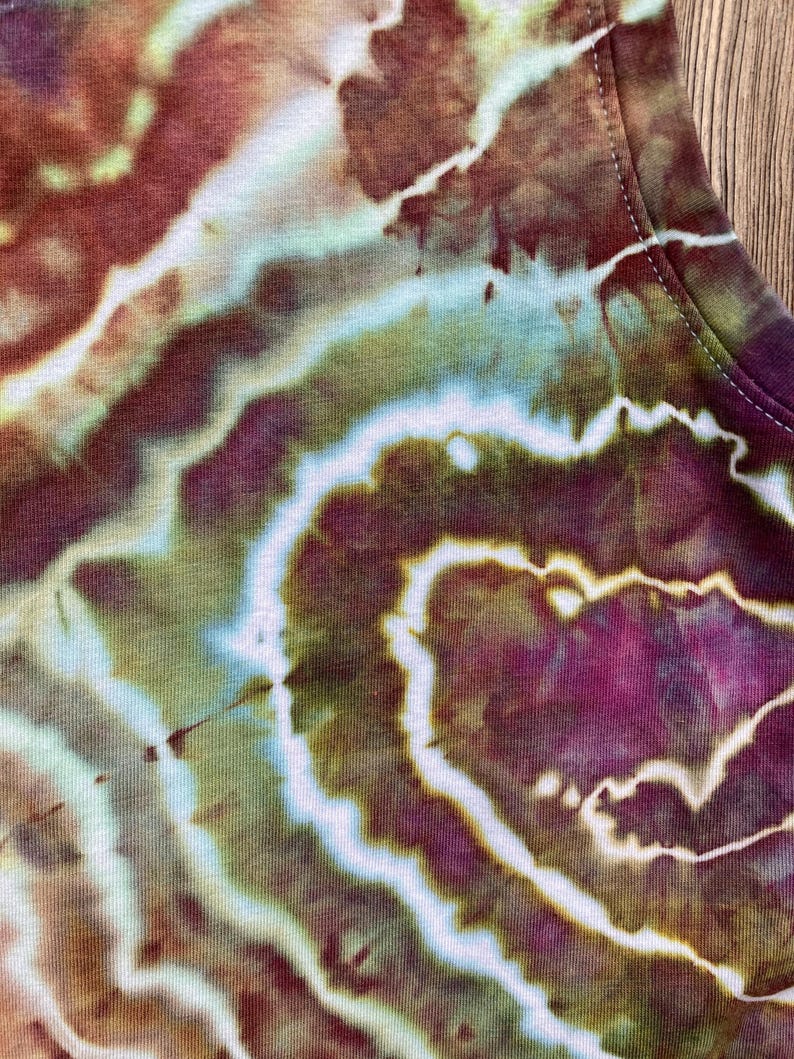 May include: Close-up of a tie-dye fabric with swirls of brown, green, and purple.