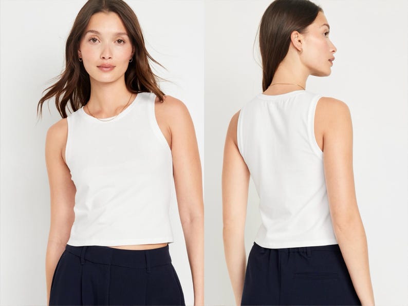 May include: White sleeveless cropped tank top with a scoop neck. The tank top is made of a soft, comfortable fabric and has a relaxed fit.