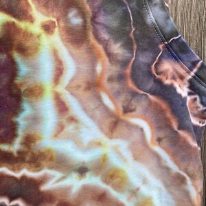 May include: A tie-dye tank top with a swirling pattern of brown, orange, yellow, and blue.