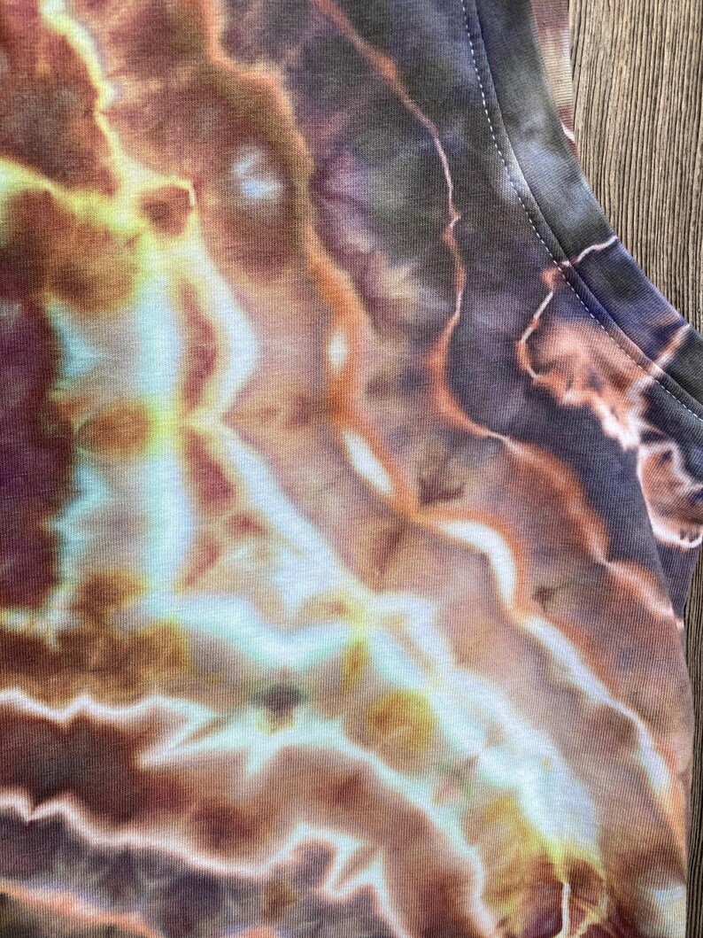 May include: A tie-dye tank top with a swirling pattern of brown, orange, yellow, and blue.