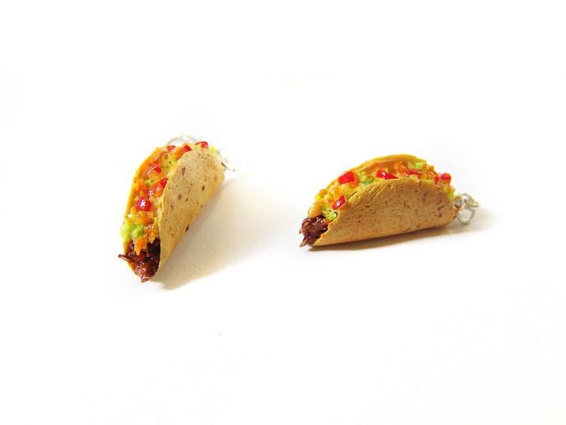 K&ouml;nnte beinhalten: Zwei Miniatur-Taco-Ohrringe aus Polymer Clay. Die Tacos sind gef&uuml;llt mit braunem Fleisch, gr&uuml;nem Guacamole und roter Salsa. Die Ohrringe sind an silbernen Ohrhaken befestigt.