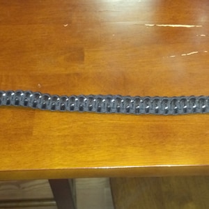 May include: A black paracord bracelet with a silver metal clasp.