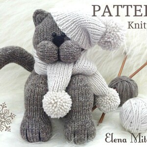 Peut inclure: Patron de tricot pour un chat gris et blanc avec un bonnet et une &eacute;charpe blancs. Le patron est intitul&eacute; "PATTERN Knitting" et est de Elena Mitchell.