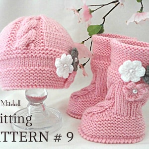 May include: Pink knitted baby hat and booties with white and gray flower embellishments. The pattern is called "Knitting Pattern #9".