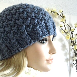 May include: A blue knitted beanie with a textured pattern. The beanie is worn on a mannequin's head.