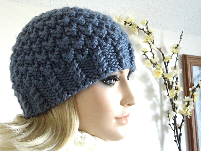 May include: A blue knitted beanie with a textured pattern. The beanie is worn on a mannequin's head.