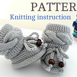 May include: Knitting pattern for baby booties with a cable knit design and brown wooden beads. The booties are gray and have a fold-over cuff.
