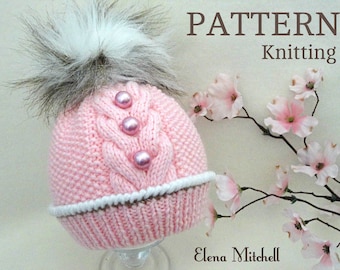 May include: Pink knitted hat with a white pom pom and pearl embellishments. The hat has a cable knit pattern and a white trim. The text "PATTERN Knitting" is visible in the image.