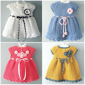 May include: Four crocheted baby dresses in different colours and styles. The dresses have a scalloped hem and are decorated with crocheted flowers.