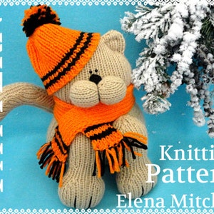 Peut inclure: Patron de tricot pour un ours en peluche beige portant un bonnet et une &eacute;charpe ray&eacute;s orange et noir. L'ours est assis sur un fond bleu avec une branche de pin enneig&eacute;e en arri&egrave;re-plan. Le texte "Knitting Pattern Elena Mitchell" est visible sur l'image.