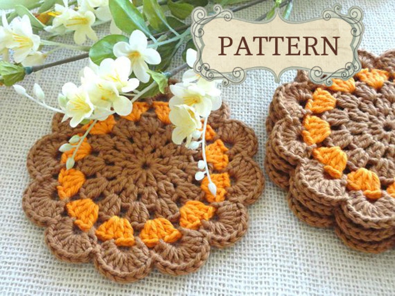 May include: Two crocheted coasters in brown and orange. The coasters are made with a circular pattern and have a scalloped edge.