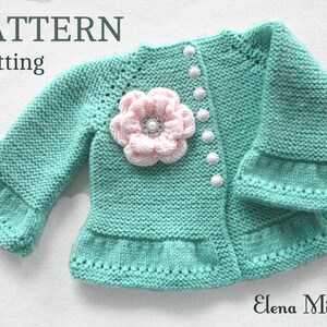 May include: A knitted baby cardigan in a light green colour with a pink flower embellishment and white buttons. The cardigan has a ruffled hem and sleeves. The text "PATTERN Knitting" is visible at the top of the image.