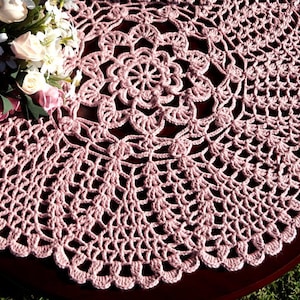 Peut inclure: Une dentelle crochet&eacute;e rose d&eacute;licate avec un motif circulaire. La dentelle a un motif floral central et un bord festonn&eacute;.