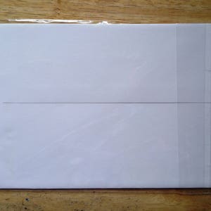 May include: A white card with a black line across the middle, inside a clear plastic sleeve.