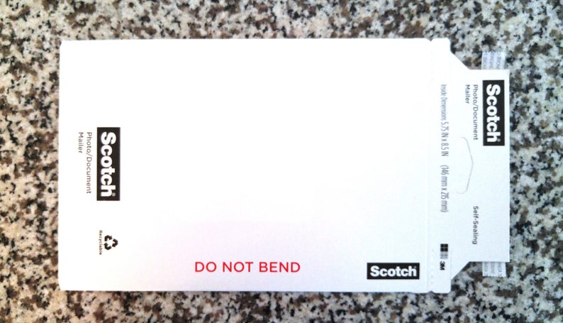 May include: White self-sealing envelope with a Scotch logo and the text "Photo/Document Mailer" and "DO NOT BEND". The envelope measures 5.75 x 8.5 inches (146 mm x 215 mm).