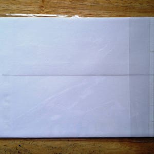 May include: A white card with a thin black line across the middle, inside a clear plastic sleeve.