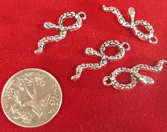 May include: Four silver snake charms with a textured surface. The charms are in the shape of a snake curled up with its tail in its mouth. The charms have a loop at the top for attaching to a necklace or bracelet.