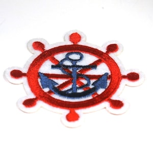 May include: A red and white embroidered patch with a blue anchor in the center. The anchor is surrounded by a red circle with white spokes. The patch is perfect for adding a nautical touch to any project.