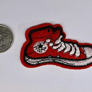 May include: Red embroidered iron-on patch of a high-top sneaker with white laces and a black star logo.