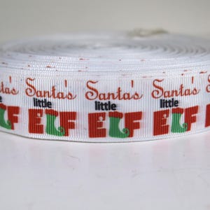 May include: White ribbon with red and green printed text that reads "Santa's little elf" repeated.