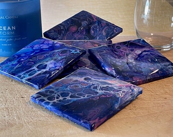 May include: Set of six square coasters featuring a blue, purple and white abstract swirl design. The coasters are made with resin and have a glossy finish.