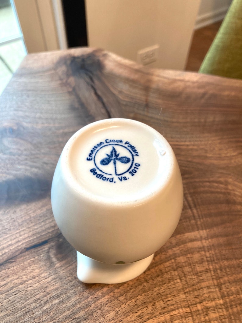 Puede incluir: Jarra de cer&aacute;mica blanca con un logotipo azul y verde que dice "Emerson Creek Pottery Bedford, Va. 2010".