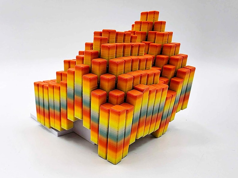 May include: A geometric sculpture composed of numerous rectangular blocks. The blocks are arranged in a stepped, pyramid-like formation. The color gradient transitions from yellow to orange, with hints of blue and green.