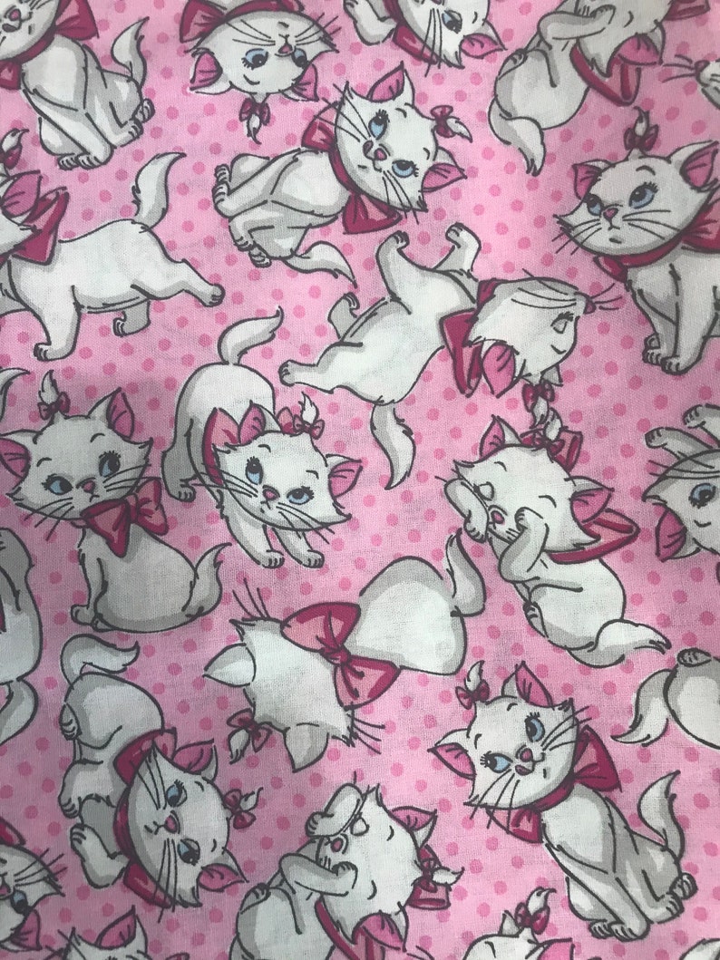 Puede incluir: Tela rosa con un patr&oacute;n repetido de gatos blancos con lazos rosas. Los gatos est&aacute;n en varias poses, algunos est&aacute;n sentados, otros de pie y otros mirando hacia un lado.