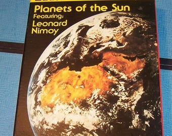 May include: A vintage VHS tape box for "Planets of the Sun" from the "Educational Favorites" series, featuring Leonard Nimoy. The cover displays an image of a planet with brown and white swirls, and the text "Nature Series".